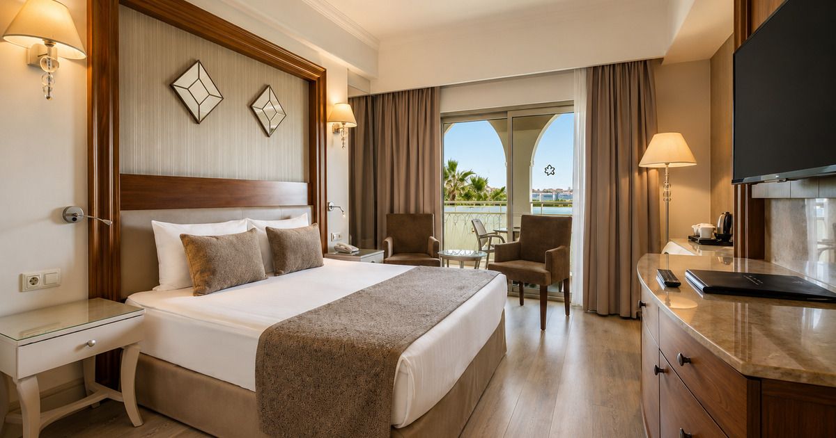Standard double room with king bed, balcony and garden view, warm lighting, Side Turkey