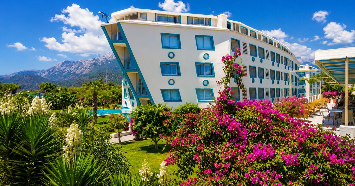 Hotel exterior with distinctive architecture, tropical garden and Taurus Mountains, Kemer Turkey