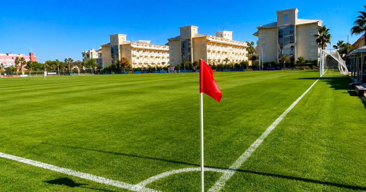 Corner flag on a professional football pitch with 5-star hotel building behind, Kemer Antalya