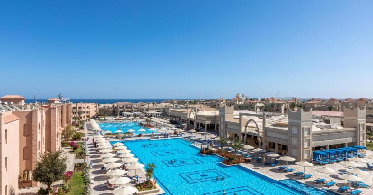 Aerial view of the 4-star resort showing large outdoor pools, sun loungers and terracotta-coloured accommodation blocks with the Red Sea visible in the background, Hurghada