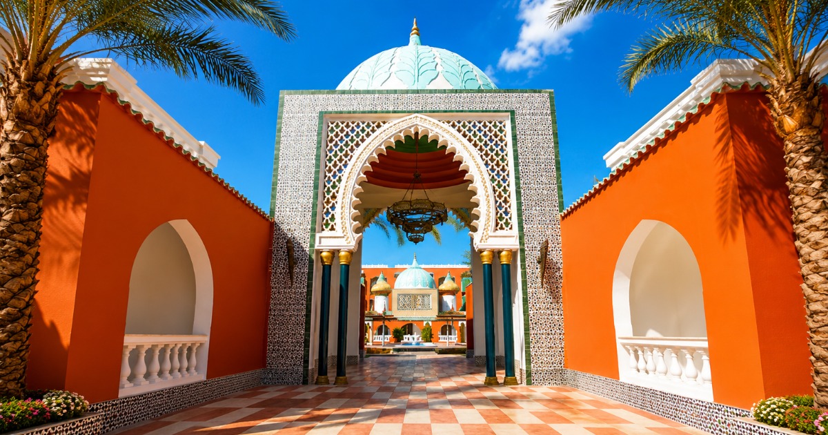 Ornate Moorish-style resort entrance gate with green tiled dome, orange rendered walls, and chequerboard courtyard, 4-star all-inclusive resort Hurghada