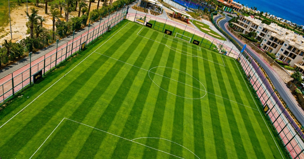 Aerial view of an artificial turf football pitch at Soma Bay with the Red Sea coast and resort villas visible in the background