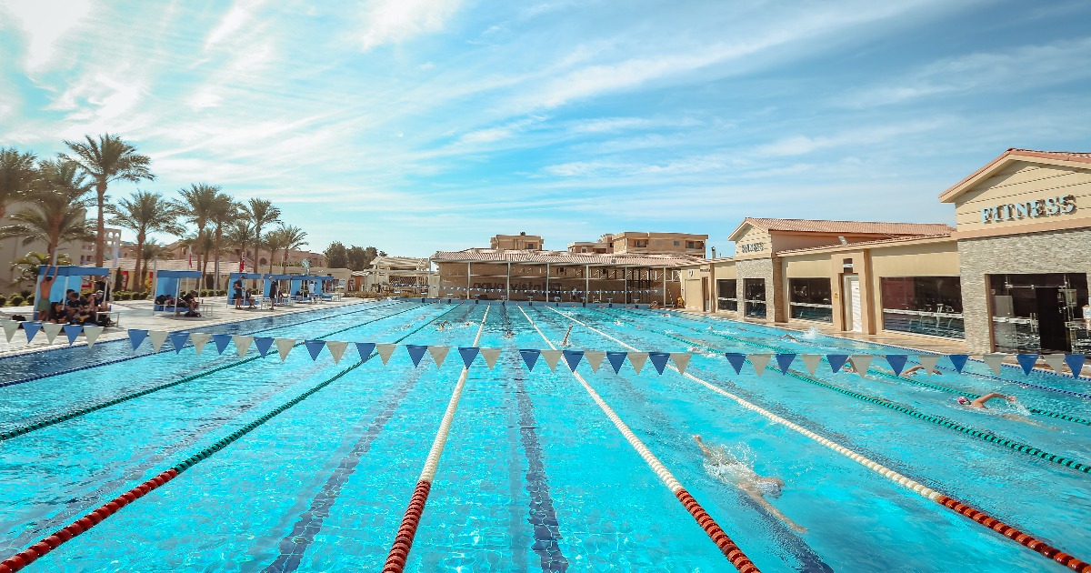 Competitive swimmers training under backstroke flags in an outdoor Olympic pool at a Red Sea resort