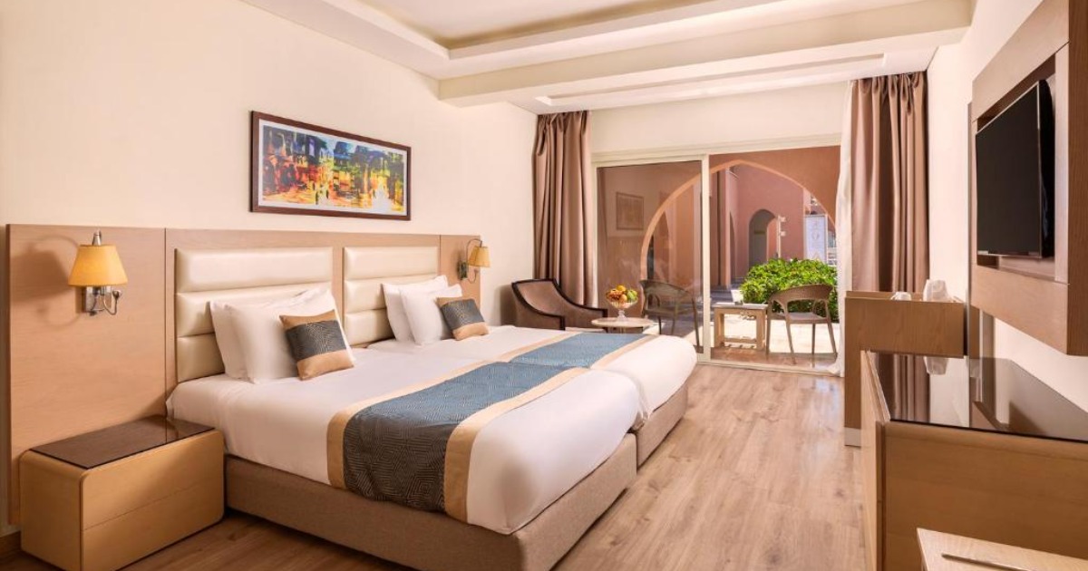 Modern twin room at the Hurghada all-inclusive resort with balcony doors and warm neutral decor
