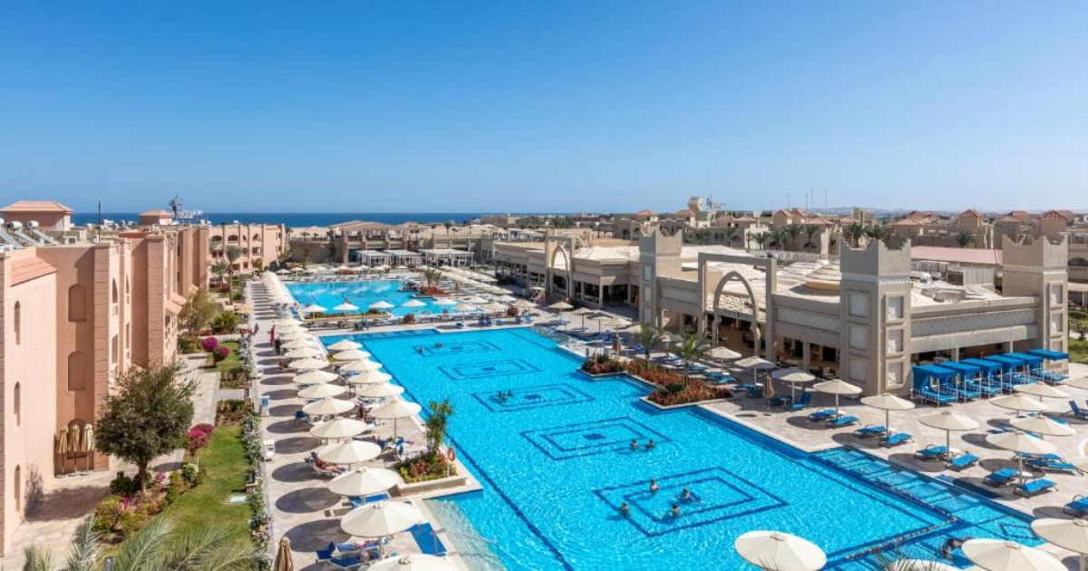 Aerial view of the Hurghada resort pools, sun terraces, hotel buildings, and Red Sea coastline