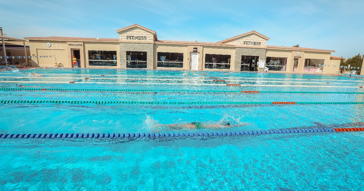 Swimmers training in a 50m outdoor Olympic pool with dedicated lanes at a Hurghada resort