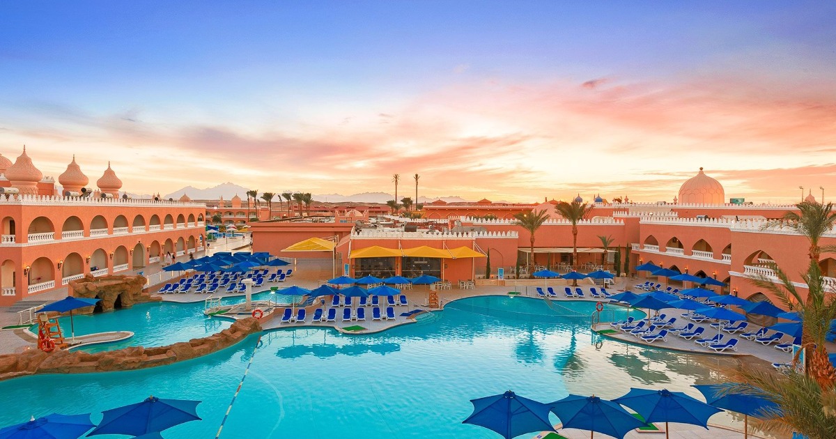 Aerial view of 4-star all-inclusive resort in Hurghada at sunset, with leisure pool, sun loungers, and Moorish-style arched architecture