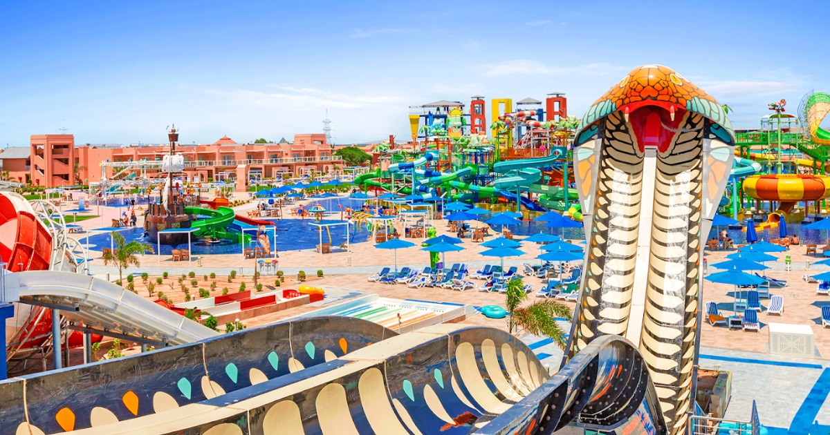 Aerial view of the resort's on-site water park in Hurghada, with colourful slides, cobra sculpture, leisure pools, and sun lounger areas
