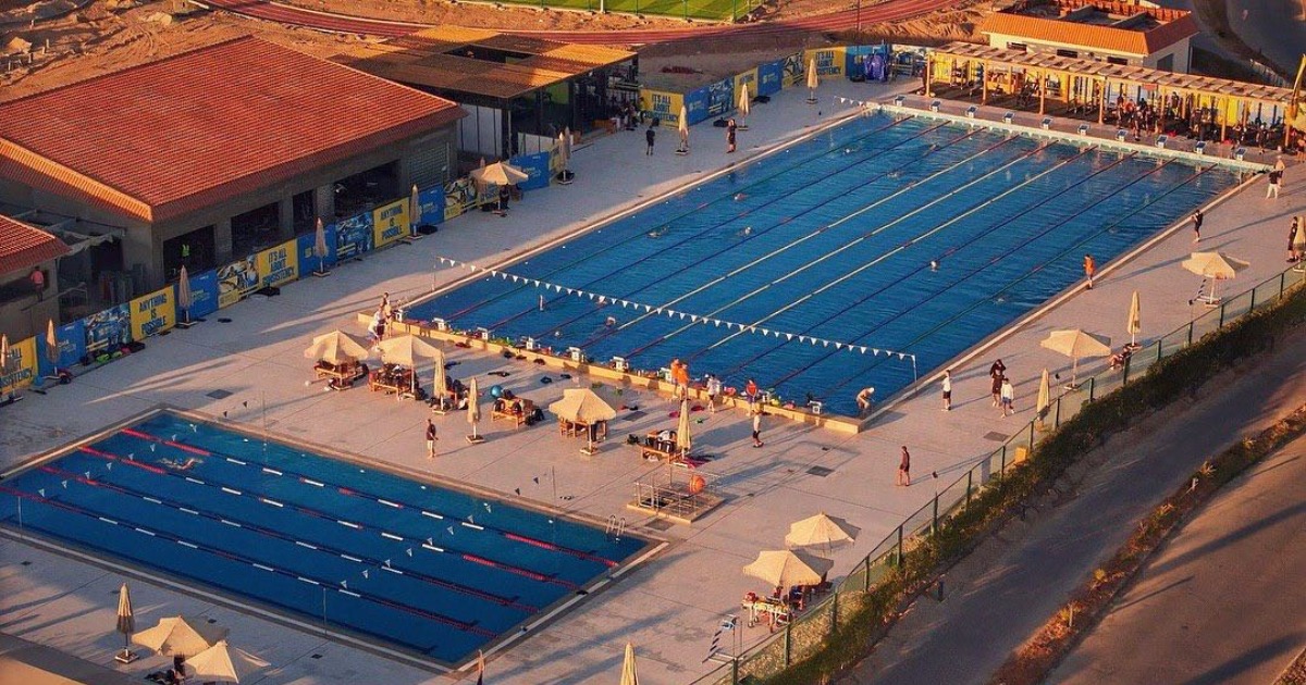 Soma Bay sports complex aerial — 50m Olympic pool, 25m pool, athletics track and football pitch visible